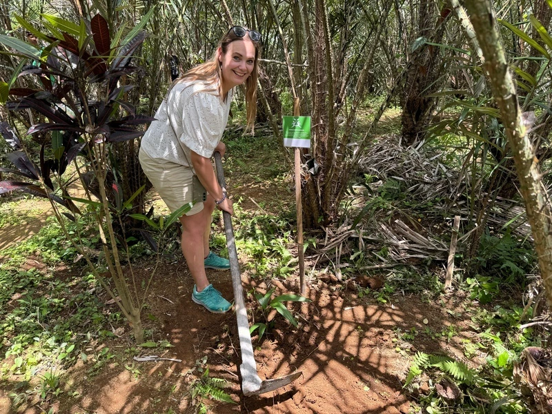 Touristin probiert Gartenarbeit wie Einheimische auf Bali