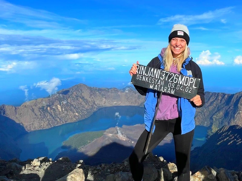 Reisende mit Gipfelschild auf dem Rinjani Vulkan auf Lombok