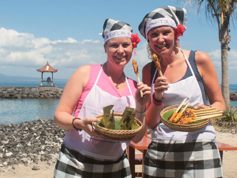 Zwei Reisende beim Kochkurs vor den Bali Pagoden am Strand in Candidasa