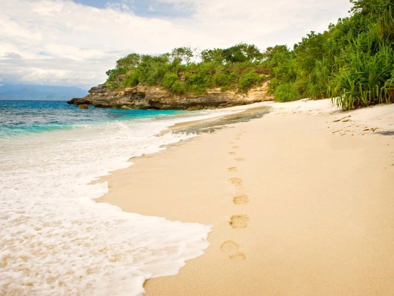 Fußspuren im Sand am Strand von Nusa Lembongan auf Bali