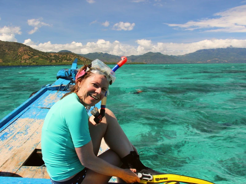 Frau mit Schnorchel und Taucherbrille auf einem Boot auf dem blauen Meer in Indonesien