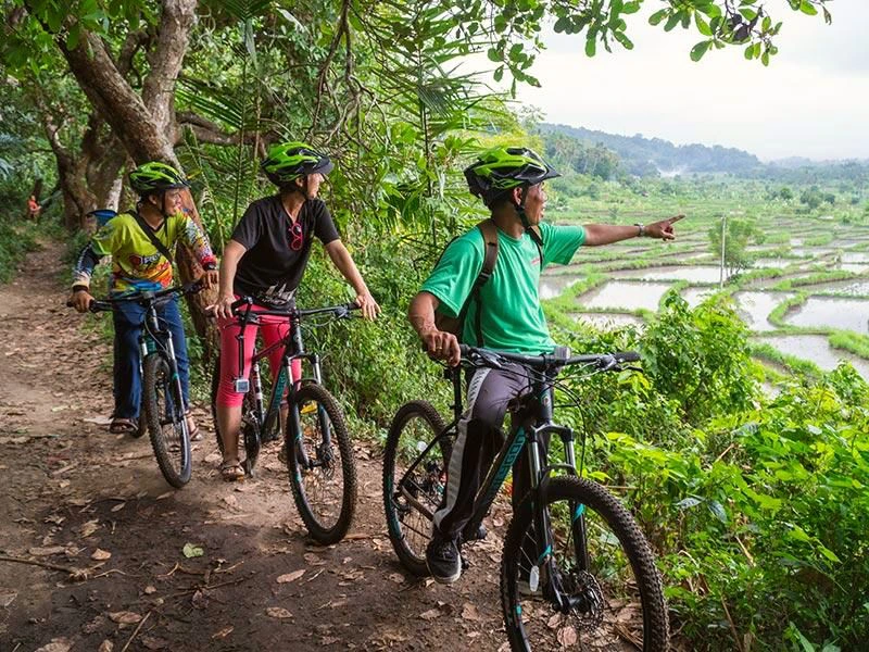 Reisende mit einem Guide bei einer Fahrradtour im Hinterland von Sibetan auf Bali
