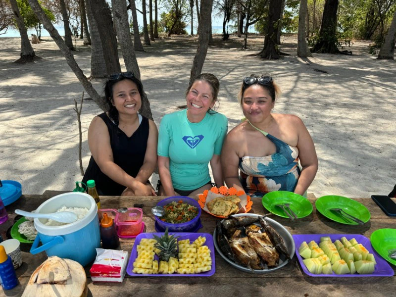 Frauen sitzen am Tisch am Strand zum Lunch bei einem Ausflug in Indonesien