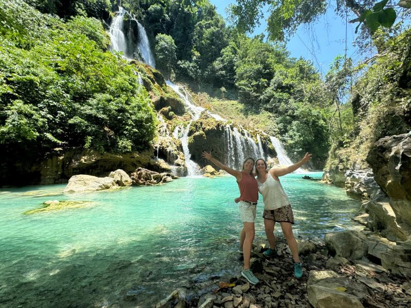 Zwei Touristinnen vor dem Lapopu Wasserfall auf Sumba, Indonesien