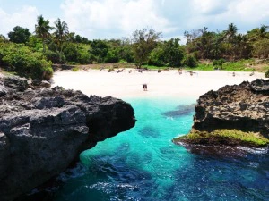 Zwei Reisende auf einem weiten Sandstrand auf Sumba