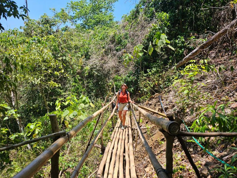 Touristin auf einer Hängebrücke im Dschungel auf Sumba, Indonesien