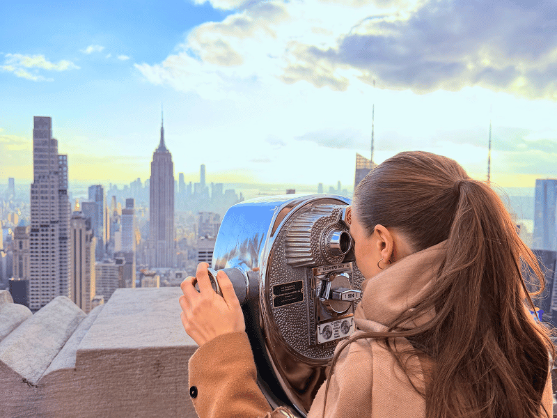 Frau am Fernglas in New York in den USA
