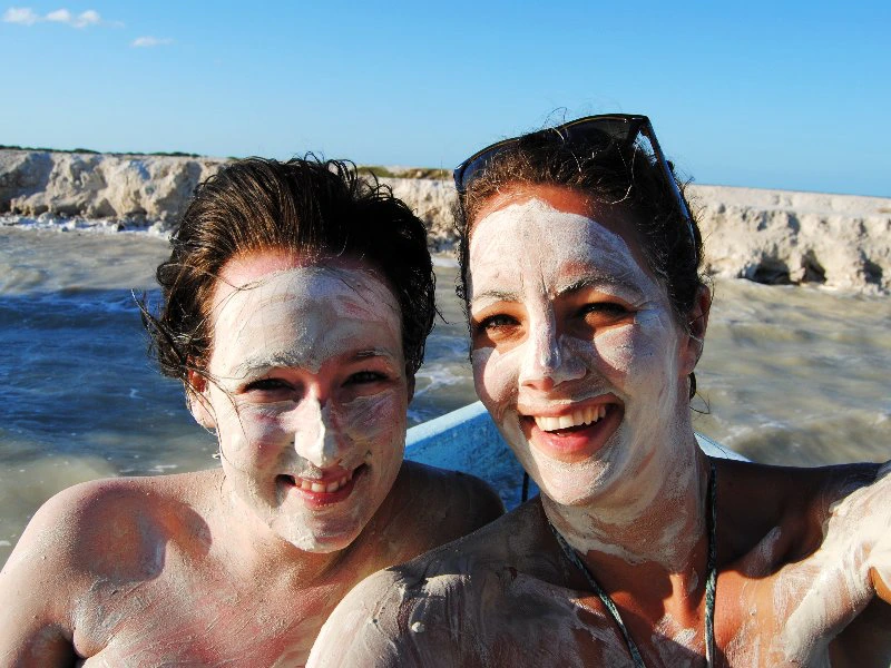 Frauen mit weissen Gesichtern vor Lagune in Mexiko