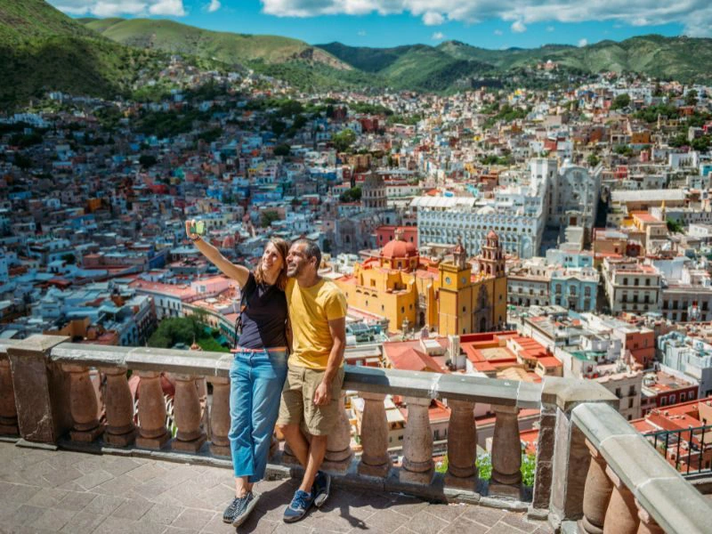 Paar macht ein Selfie vor der Kulisse von Guanajuato in Mexiko