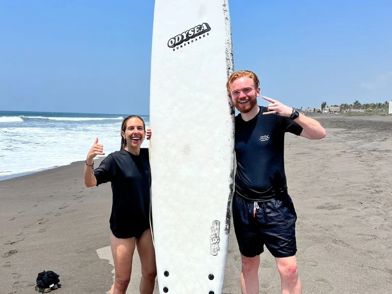 Ein Surferpaar mit Surfbrett am Strand von El Paredon, Guatemala