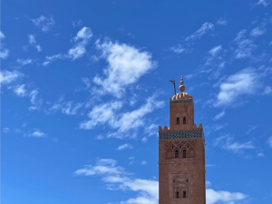 Oberes Ende der Koutoubia Moschee vor blauem Himmel mit weißen Wolken in Marrakesch