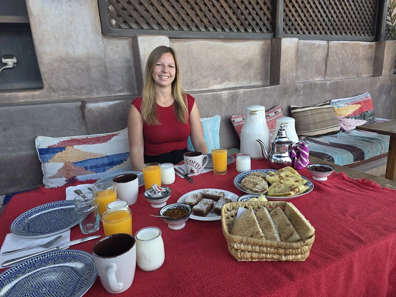 Frau am gedeckten Frühstückstisch eines Riads in Marrakesch