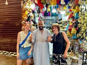 Reisende mit einem Local vor einem kleinen Geschäft in Marrakesch, Marokko