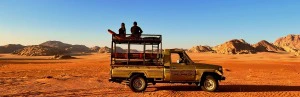 Offroad Jeep mit Menschen im Wadi Rum, Jordanien