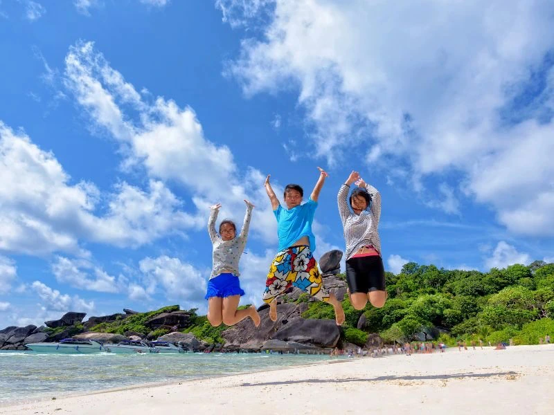 Kinder springen am Strand von Koh Phangan in Thailand
