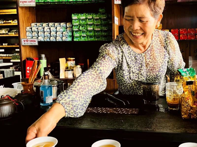 Thailändische Frau in einem Teeladen hinter der Theke