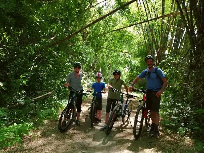 Familie beim Ausflug mit Fahrrädern in einem Bambuswald in Nordthailand
