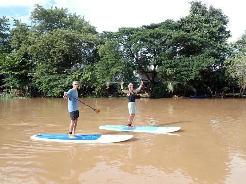 Touristen beim Stand-up Paddling auf dem Ping Fluss in Chiang Mai in Thailand