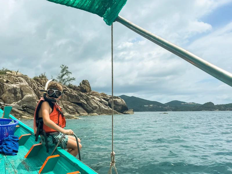 Kind mit Schnorchelausrüstung auf einem Boot auf dem Meer in Thailand