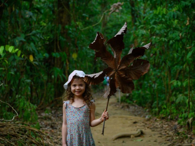 Kind hält ein großes Blatt in der Hand in Costa Rica