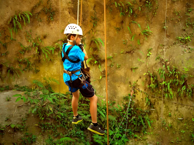 Kind beim gesicherten Klettern im Nebelwald in Costa Rica