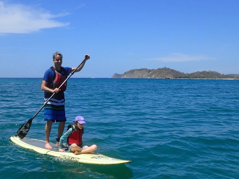 Vater mit Kind beim Stand-up-Paddling in Costa Rica