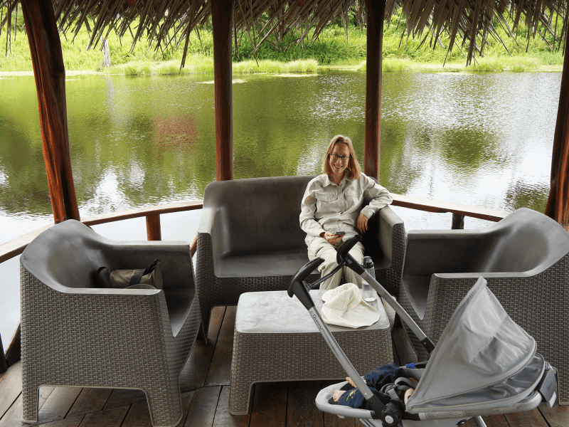 Frau in Pavillion auf einem See mit Kind im Buggy