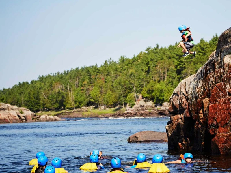 Junge springt vom Felsen ins Wasser am Ottawa River in Kanada