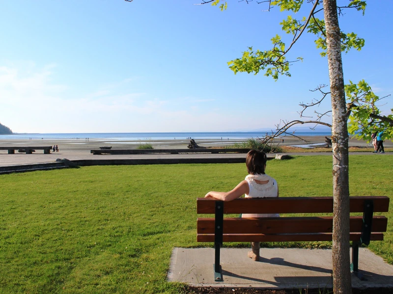 Frau sitzt auf Bank in Parksville in Kanada.