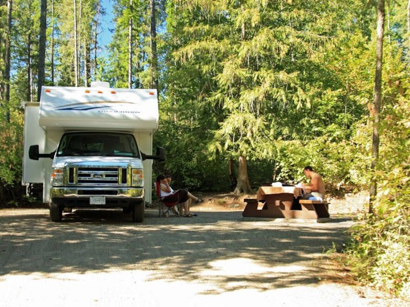 Wohnmobil von vorne auf einem Campingplatz im Wald in Kanada