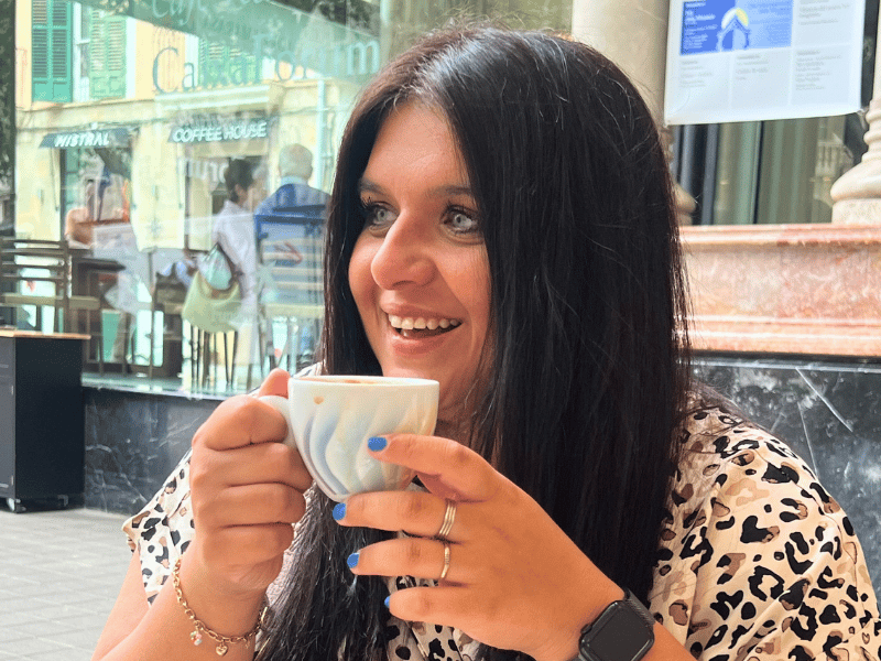 Frau trinkt Kaffee aus einer weißen Tasse in einem Café