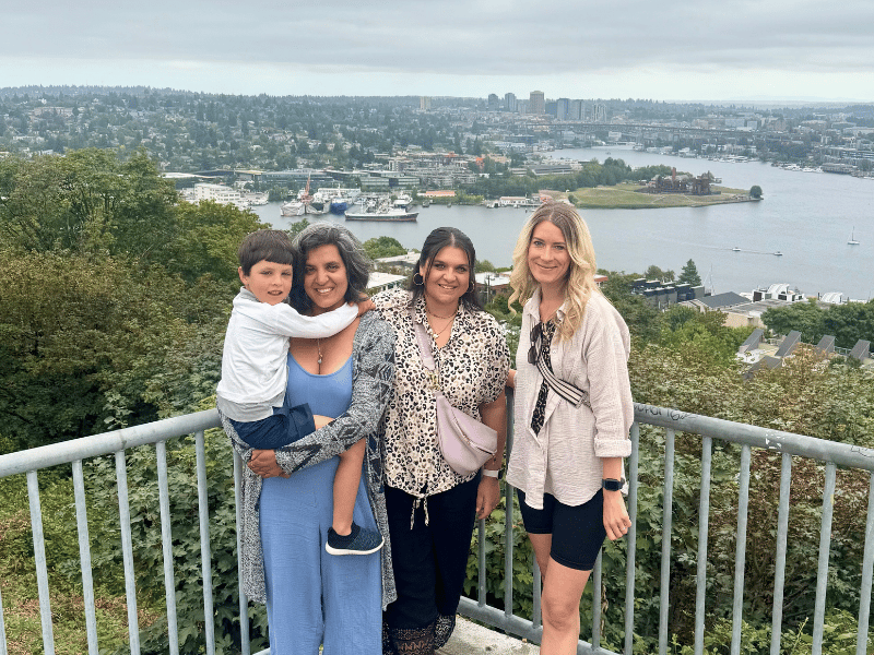 Drei Frauen und ein Kind auf einer Aussichtsplattform mit der Stadt Seattle im Hintergrund