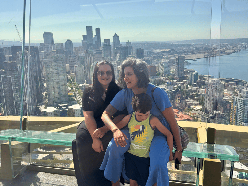 Zwei Frauen und ein Kind auf gläserner Bank in der Space Needle in Seattle
