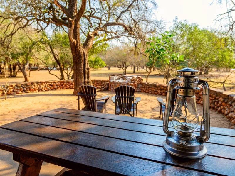 Öllampe auf einem Holztisch zwischen trockener Landschaft in Eswatini