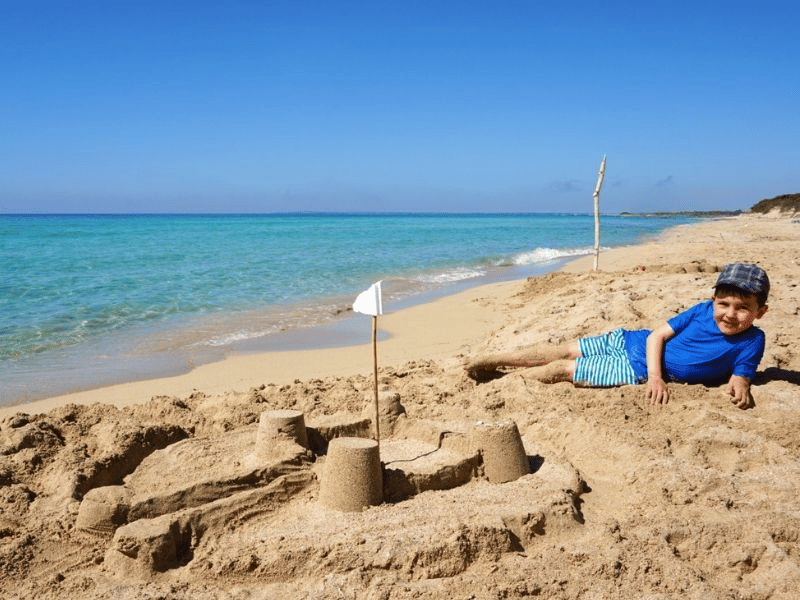 Junge am Strand von Mahé Seychellen