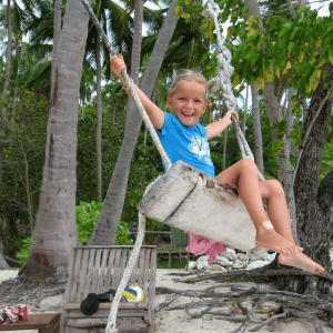 Mädchen auf Schaukel auf Praslin Seychellen