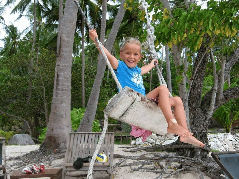 Mädchen auf Schaukel auf Praslin Seychellen