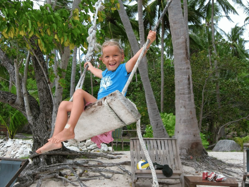 Mädchen auf Schaukel auf Praslin Seychellen