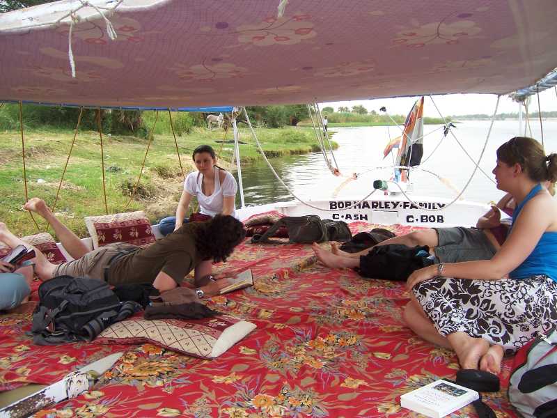 Reisende machen es sich gemütlich auf der Feluke in Ägypten.