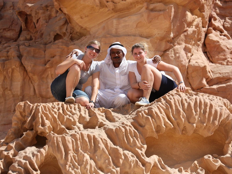 Gruppenbild auf den Sandfelsen in Ägypten mit Einheimischen