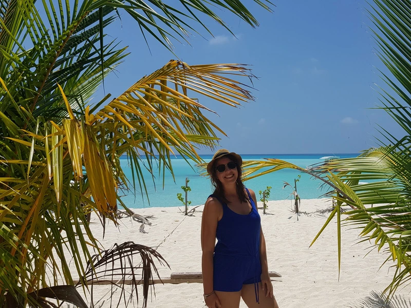 Frau unter Palmen am Strand auf den Malediven