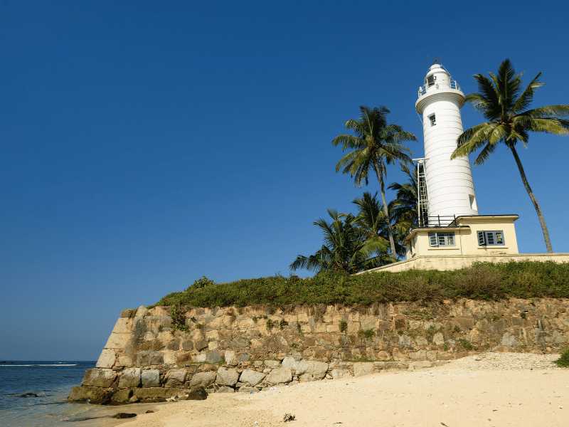 Weißer Leuchtturm am Meer und Strand in Galle in Sri Lanka