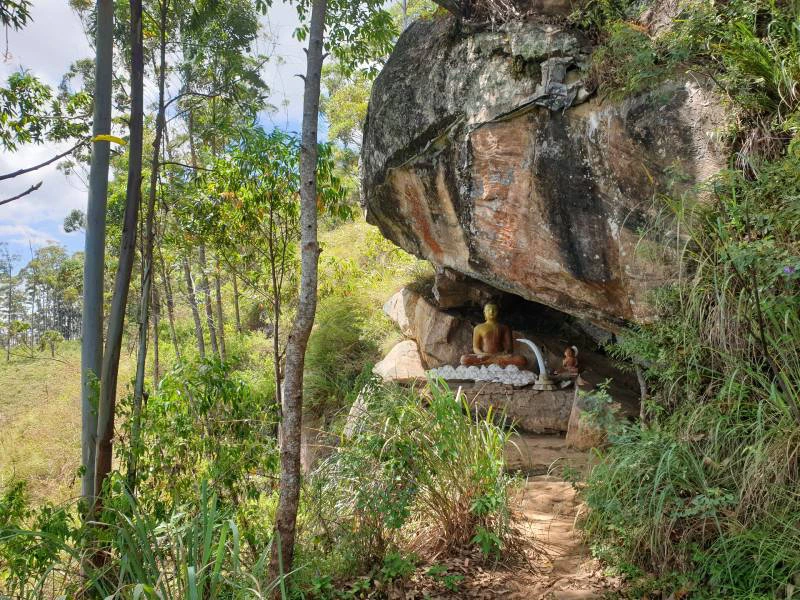 Kleiner Buddha unter einem Felsvorsprung am Pekoe Trail in Sri Lanka