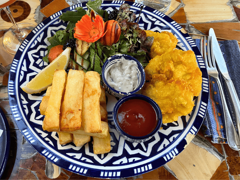 Fish and Chips mit Salat und Soße auf blau weißem marokkanischem Teller