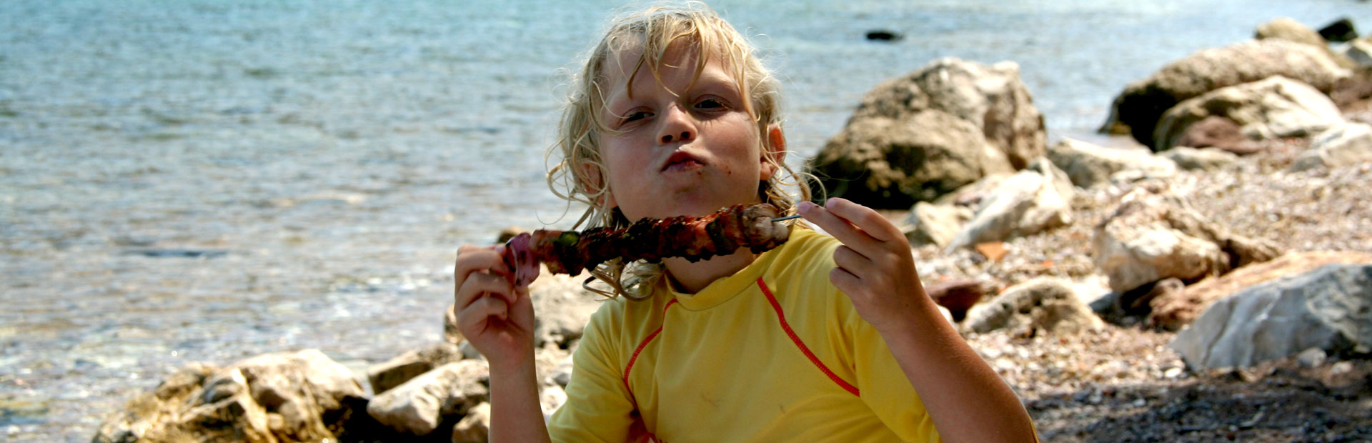 Kind isst am Strand Marokko