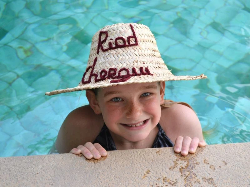 Kind im Pool lacht in die Kamera Marokko