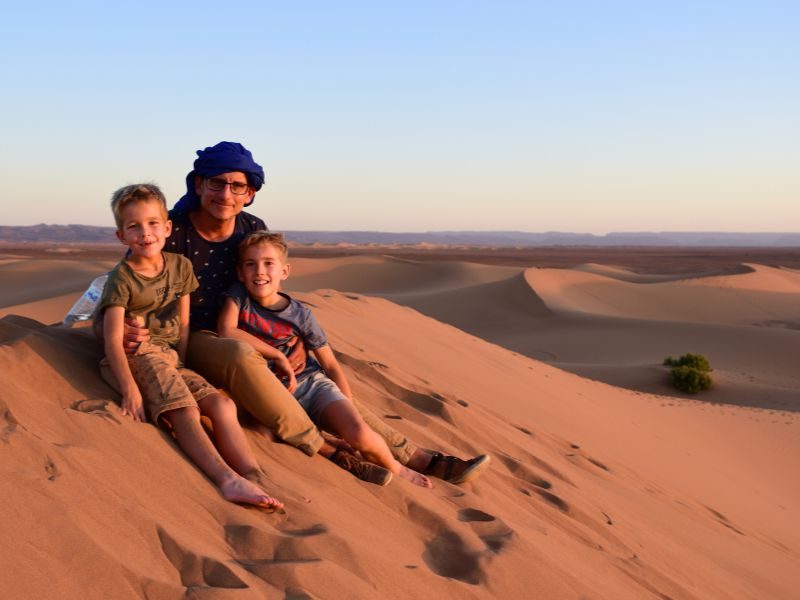 Familie beim Sonnenuntergang in den Dünen, Marokko