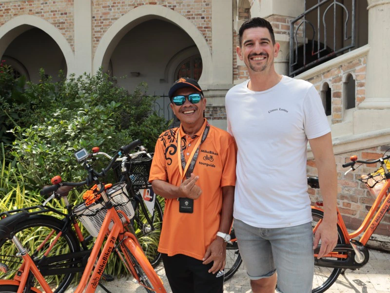 Tourist mit Guide bei einer Radtour in Kuala Lumpur