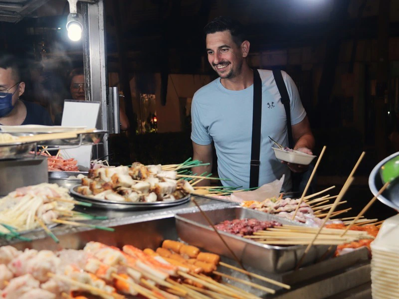Mann an einem Streetfood Stand in Kuala Lumpur
