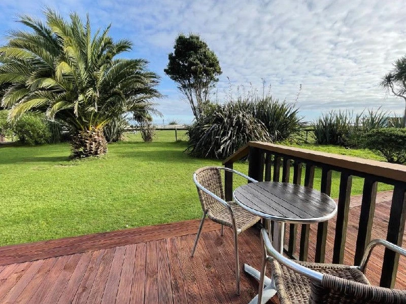 Chalet Terrasse mit Palmen und Meer im Hintergrund in Hokitika, Neuseeland
